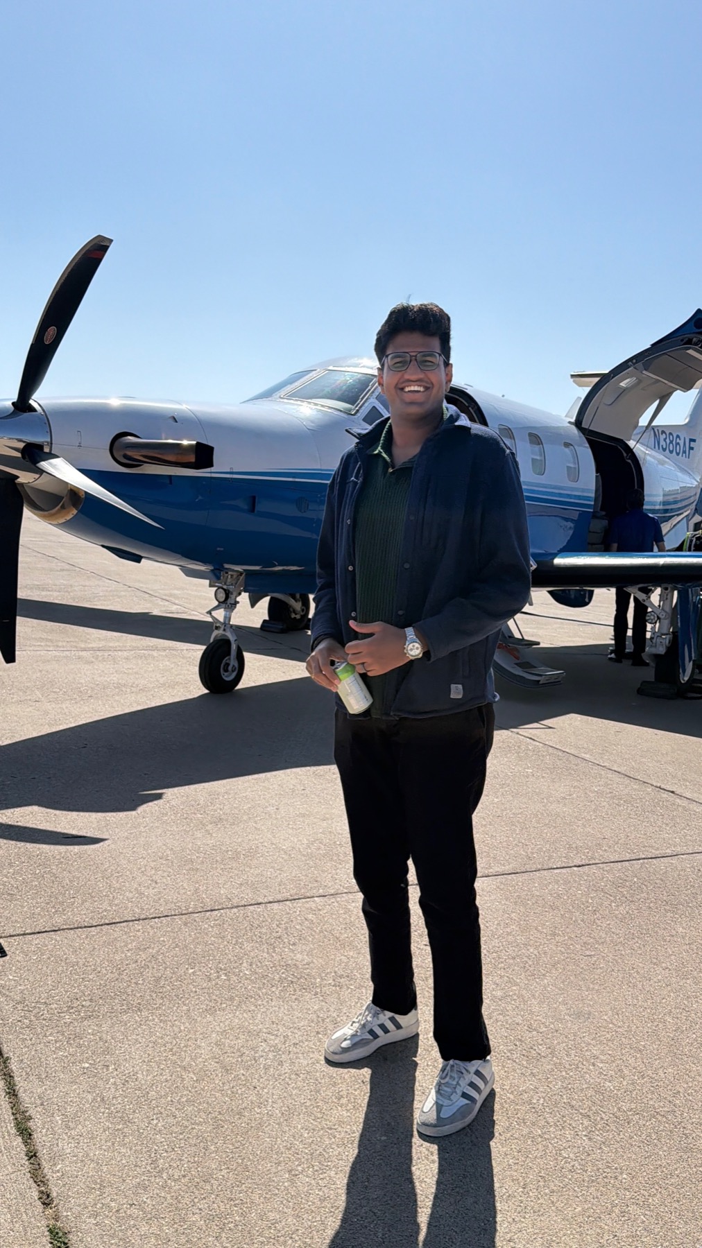 Kartik smiling in front of the private jet before flying to San Francisco